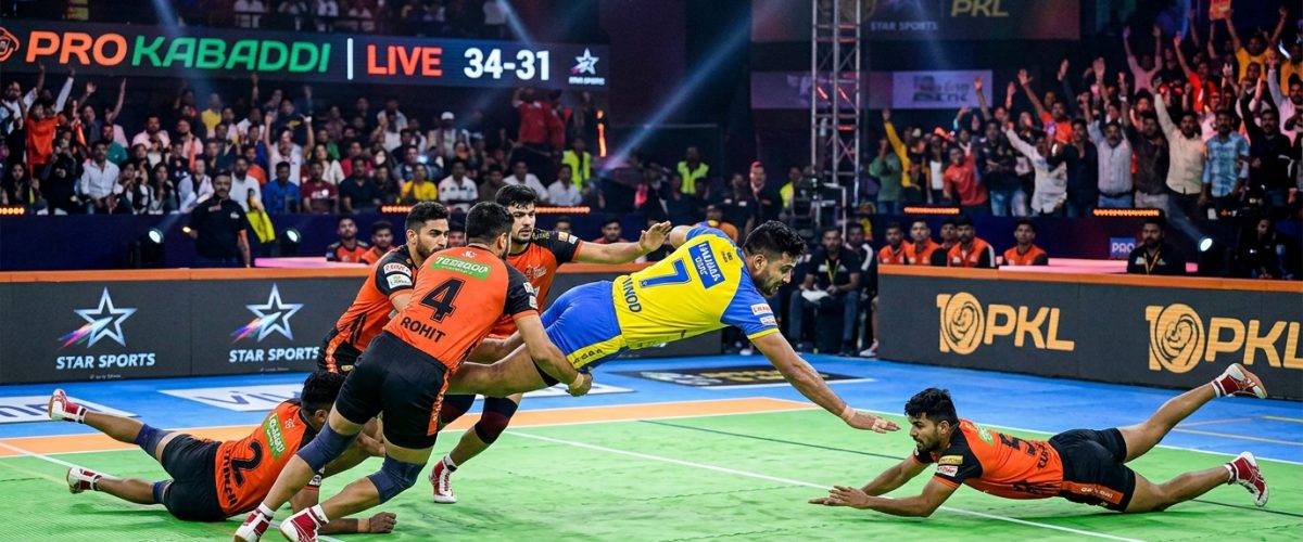 Pro Kabaddi League player performing raid in front of packed stadium