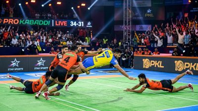Pro Kabaddi League player performing raid in front of packed stadium
