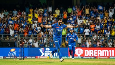 Indian cricket bowler celebrating wicket at packed IPL stadium under floodlights