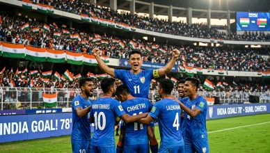 Indian football team celebrating goal in blue jerseys at packed stadium