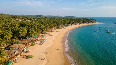 Serene Goa beach in April off-season with golden sand and calm turquoise Arabian Sea