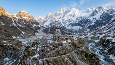 Himalayan temple shrine among snow-capped mountains with pilgrims on mountain path