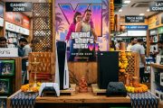 PlayStation 5 and Xbox Series X consoles on display with GTA VI promotional material