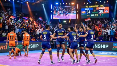 Pro Kabaddi League match action in a packed indoor stadium with team celebrating