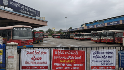 Empty Telangana bus terminal with idle state transport buses and protest banners during RTC strike