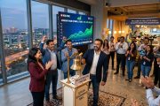 Modern Indian startup office celebrating IPO with stock exchange bell and growth charts